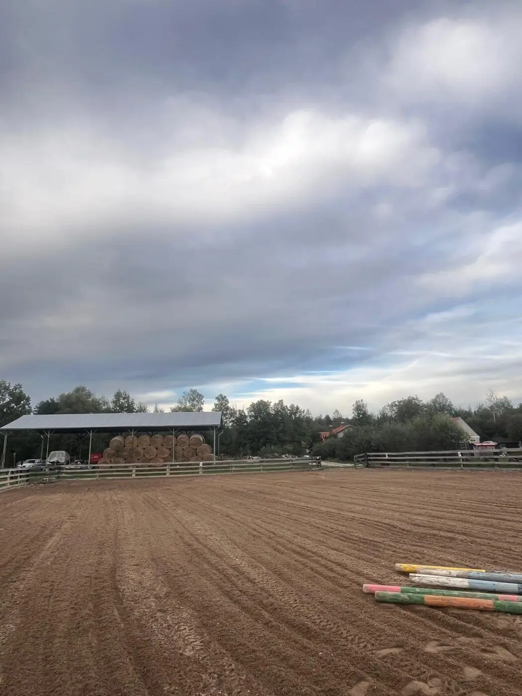 Písková jízdárna 20 × 40 m, v pozadí kryté seníky